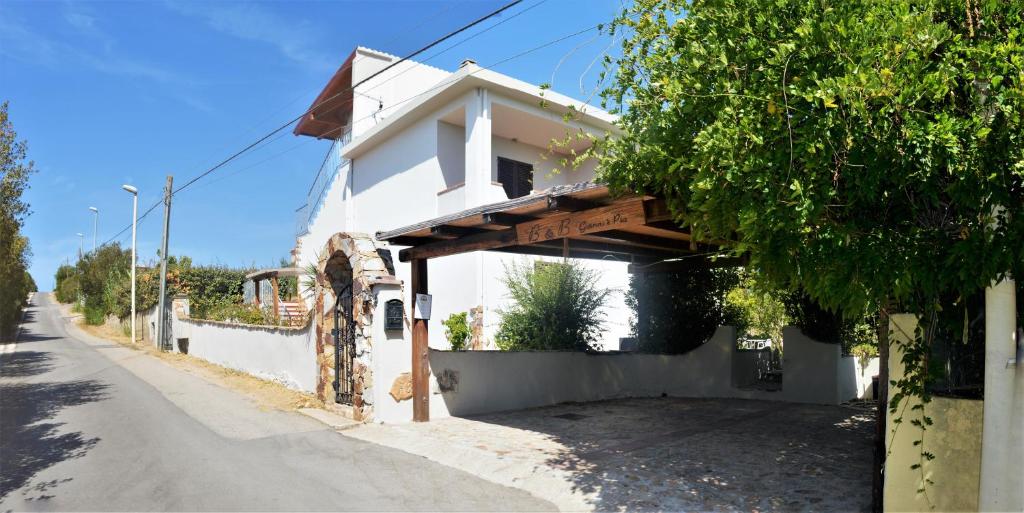 een wit huis aan de kant van een straat bij B&B Gianni e Pia in Luogosanto