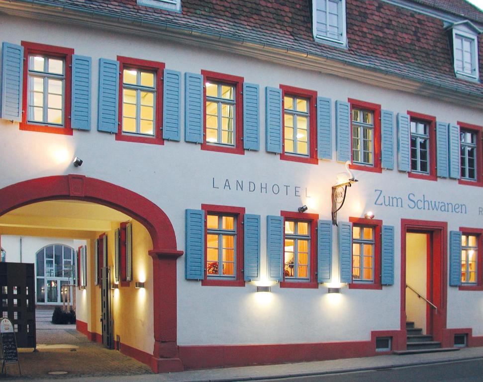 a building with red and blue shuttered windows at Landhotel zum Schwanen mit Restaurant Mona Liza in Osthofen
