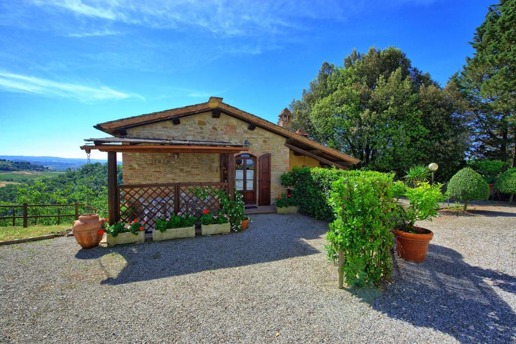 サン・ジミニャーノにあるAzienda Agricola Fornacelleの門と植物のある小さなレンガ造りの家