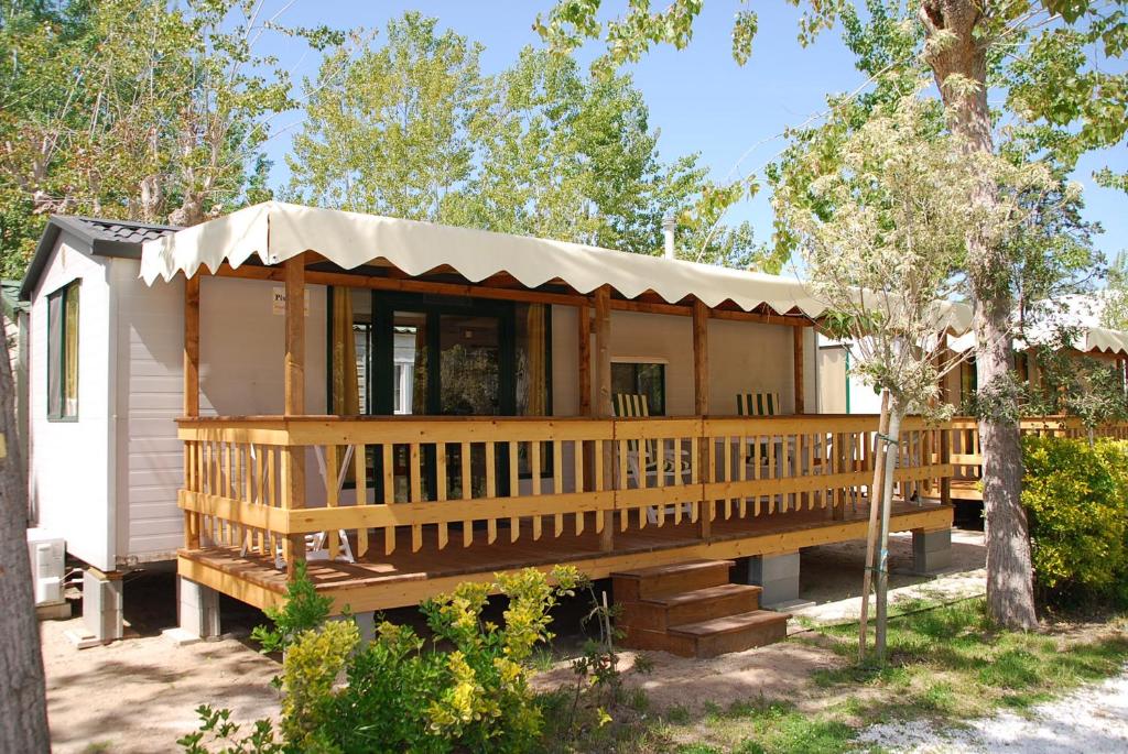a cabin with a large deck in the woods at Brevar - Toscane in Torre del Lago Puccini