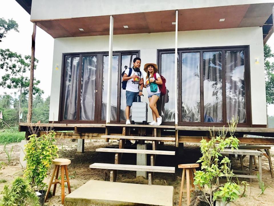 a man and woman standing on the porch of a house at Villa Encantador Resort in San Vicente