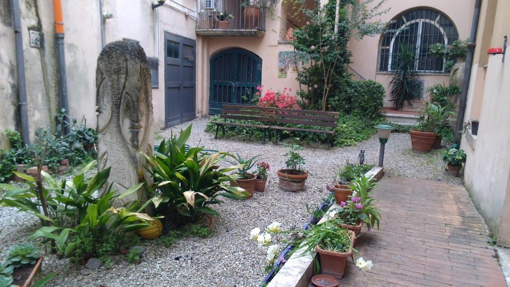 um jardim com um banco e plantas em frente a um edifício em Residence 1810 em Benevento