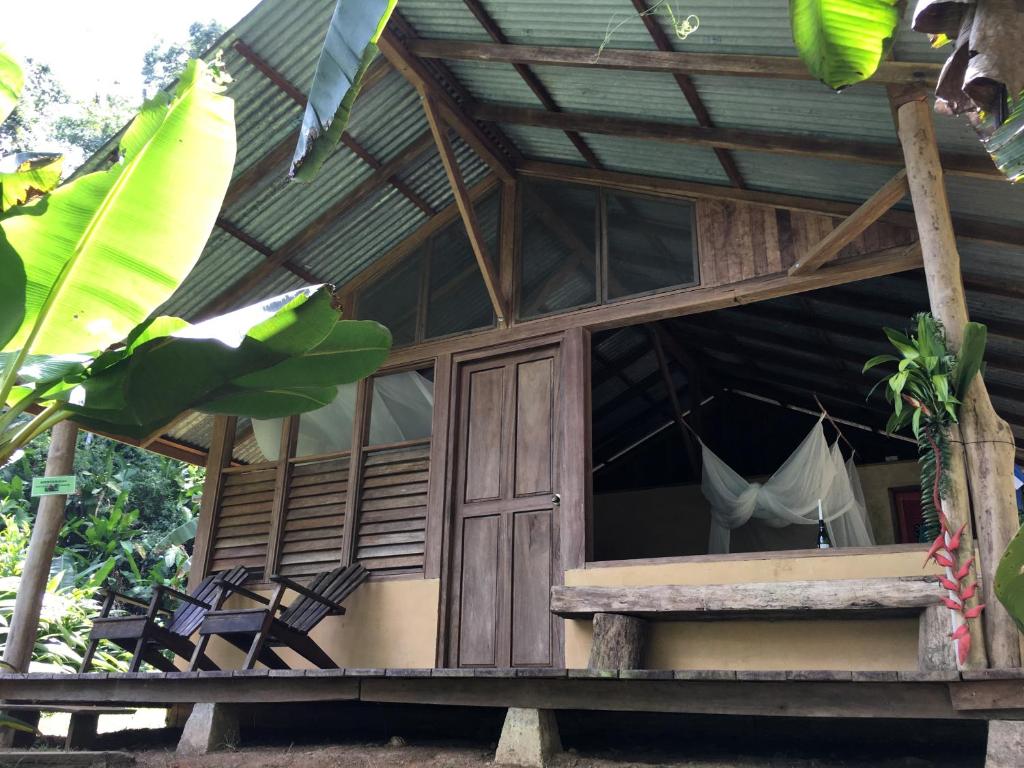 ein Holzhaus mit einer Hängematte im Fenster in der Unterkunft Amazonita Ecolodge in Dos Brazos