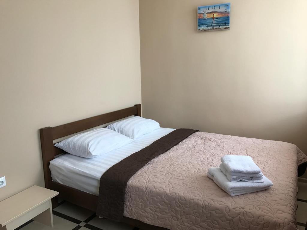 1 dormitorio con 1 cama con 2 toallas en Asteria en Odesa
