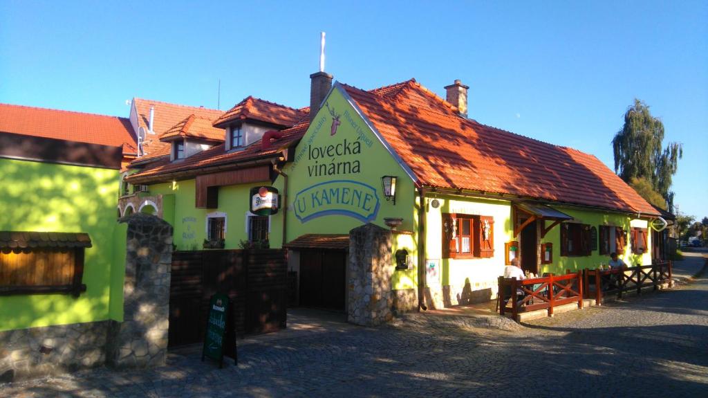 a green and white building with a red roof at Šestajovický pivovar ubytování in Šestajovice