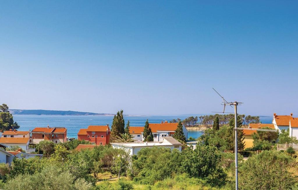 a view of a town with the ocean in the background at APARTMANI SANDRA PRPIĆ in Rab