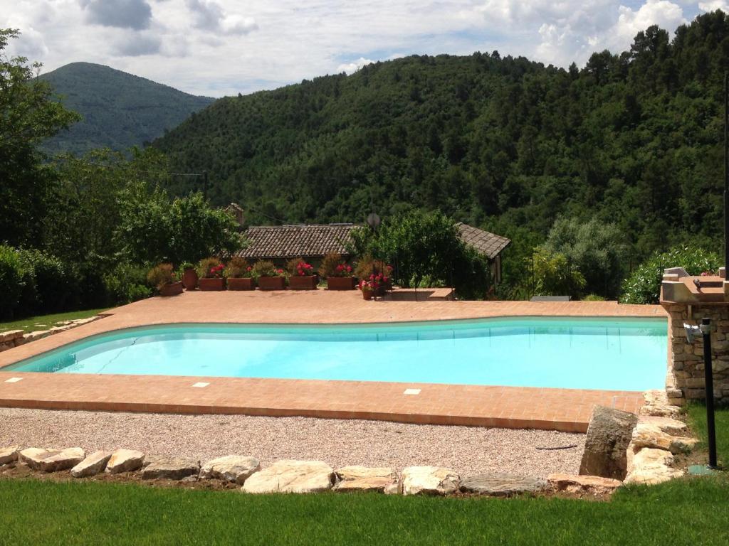 a swimming pool in a yard with mountains in the background at Ancaiano Country House in Ferentillo