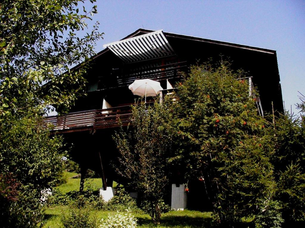 una casa negra con árboles delante de ella en Ferienwohnung Teddy, en Siegsdorf