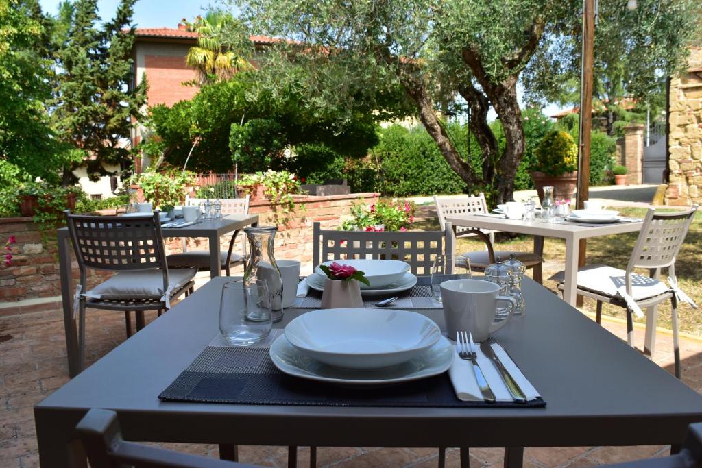 a table with plates and utensils on a patio at Villa San Michele in Barberino di Val dʼElsa