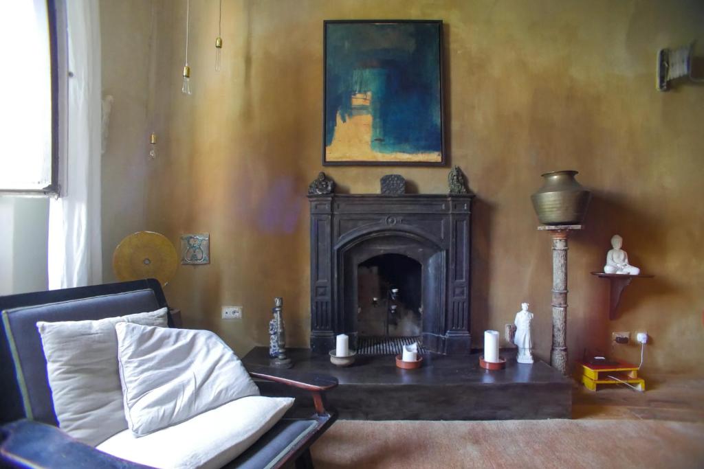 a living room with a fireplace and a chair at La Maison at The Old Bridge in Florence