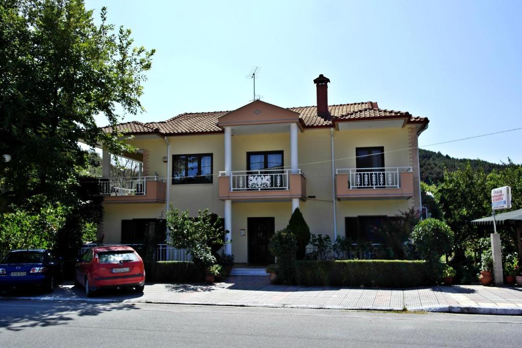 a house with a car parked in front of it at Roula Rooms in Stratoni