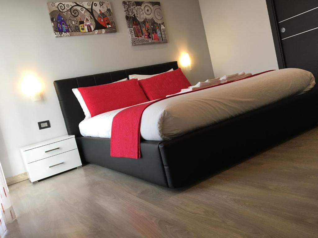 ein Schlafzimmer mit einem großen Bett mit roten Kissen in der Unterkunft 85Centro in Potenza