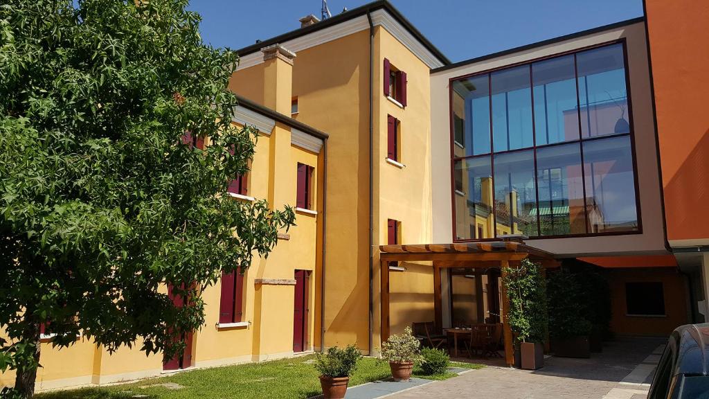 メストレにあるUNAWAY Ecohotel Villa Costanza Veneziaの大きな窓のある黄色の建物