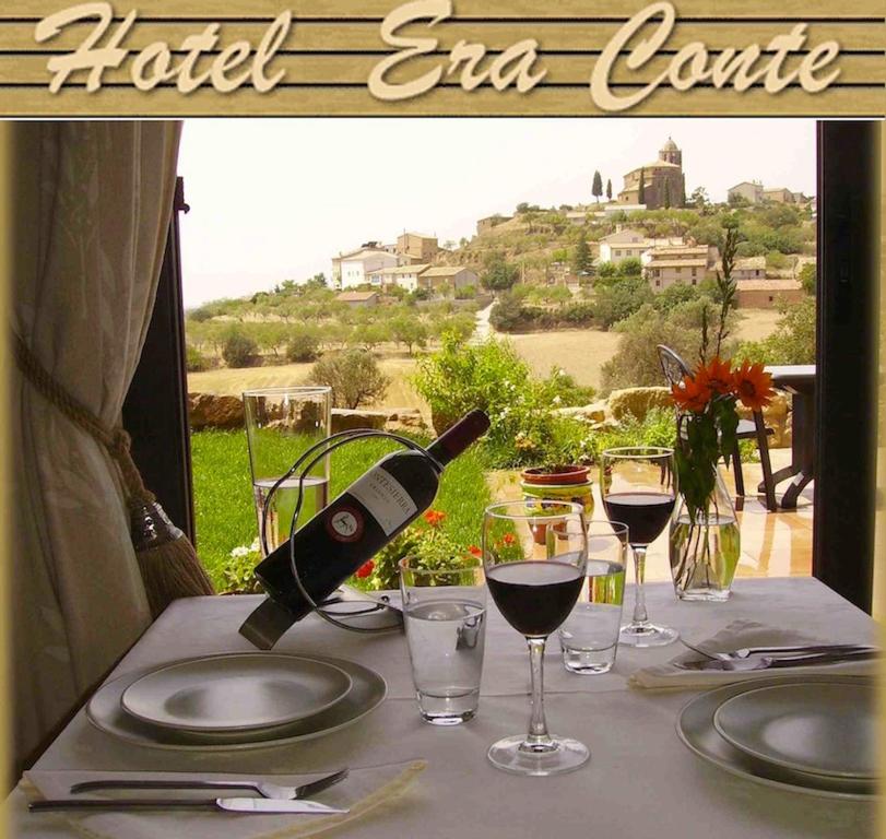 a bottle of wine sitting on a table with glasses at Hotel Era Conte in Bierge