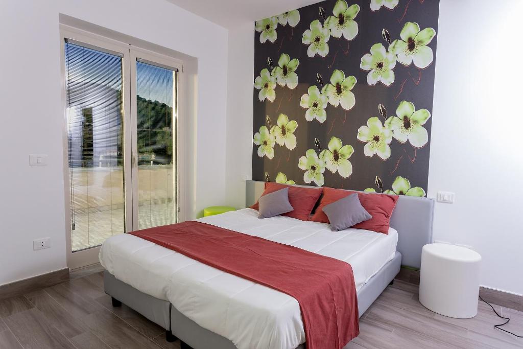 1 dormitorio con 1 cama grande con flores en la pared en Villa D'Elite, en Montecorice