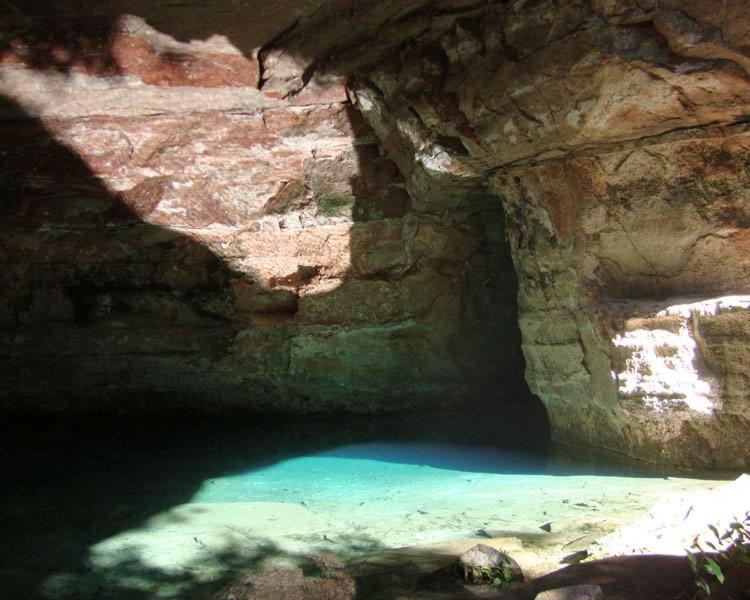 een grot met een zwembad van blauw water erin bij Pousada Portal do Peruaçu in Januária