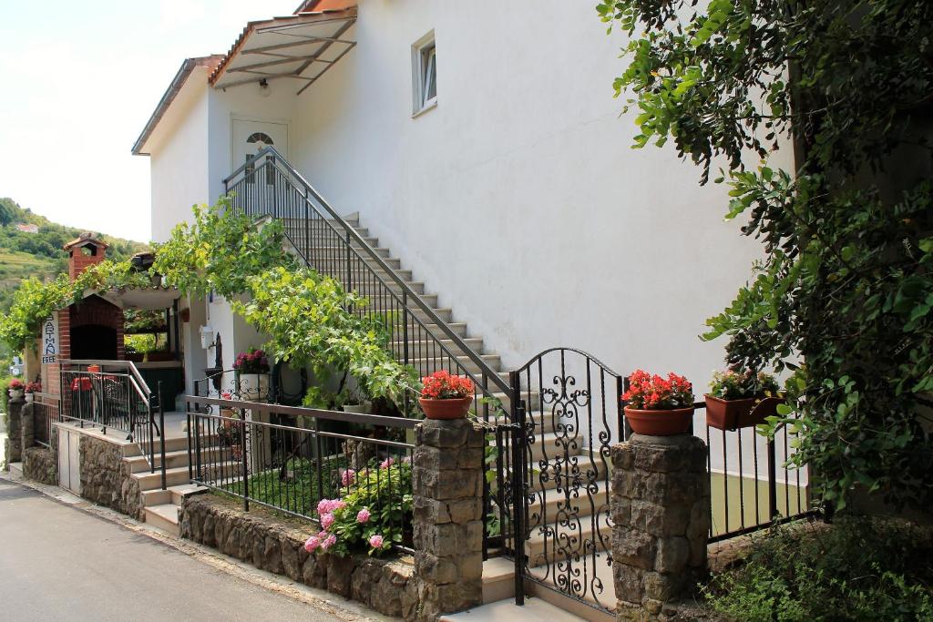 una casa con una puerta de hierro forjado y flores en Apartments Tanja, en Živogošće