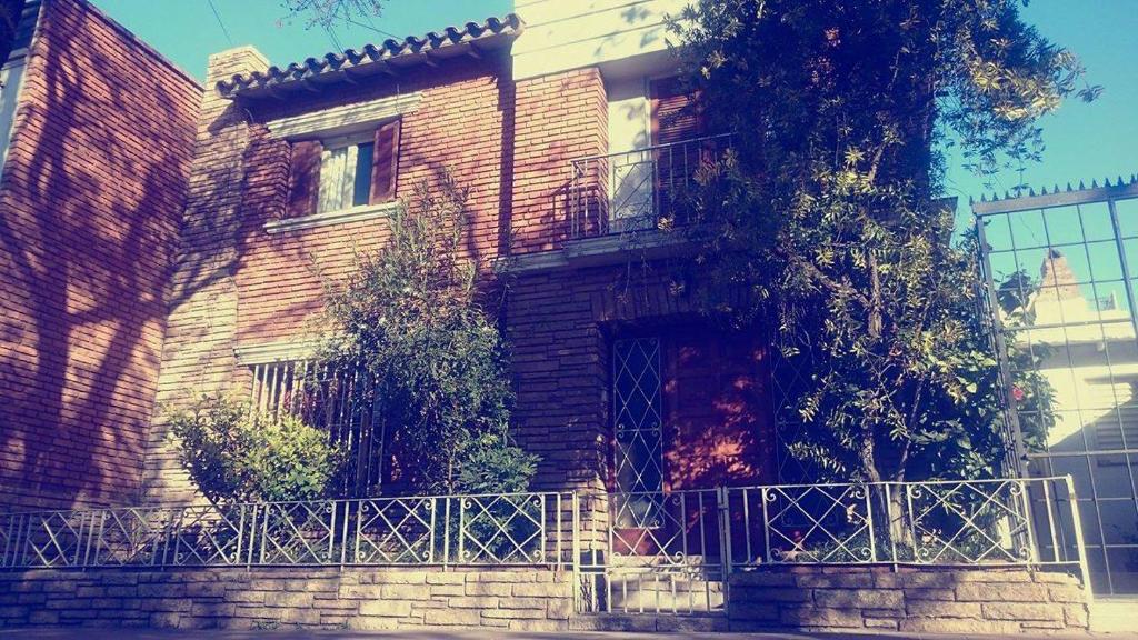 uma casa de tijolos com uma cerca em frente em Sentite como en casa em Mendoza