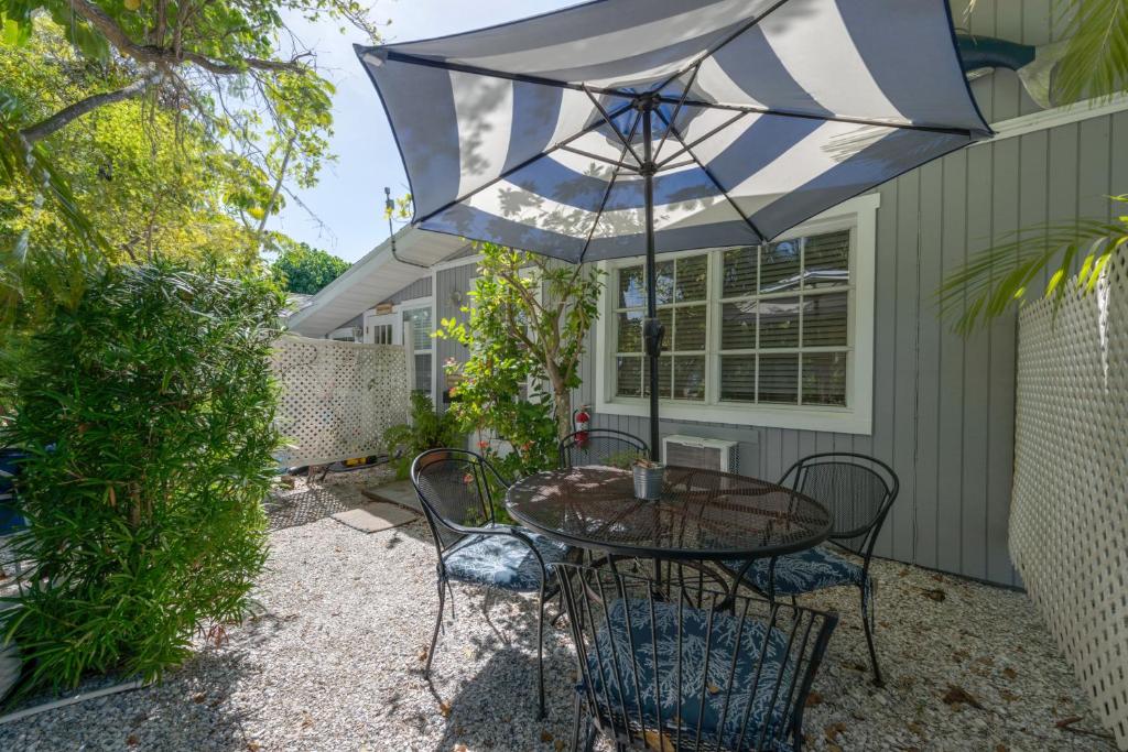 a patio with a table and chairs and an umbrella at Tarpon Tale Inn in Sanibel