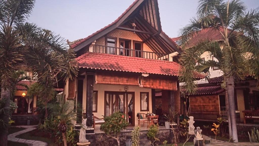una casa con palmeras delante en Tradisi Villas, en Amed