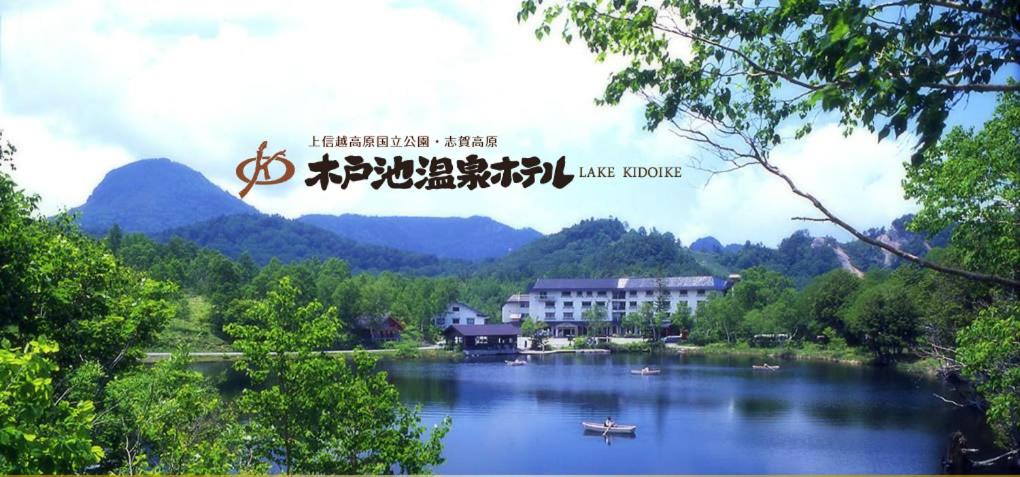a view of a lake with mountains in the background at Kidoike Onsen Hotel in Yamanouchi