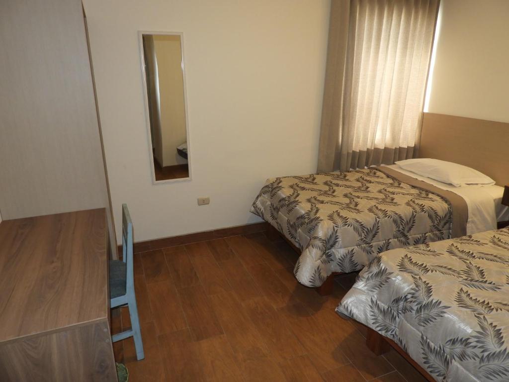 Postel nebo postele na pokoji v ubytování Nice Inn Tacna