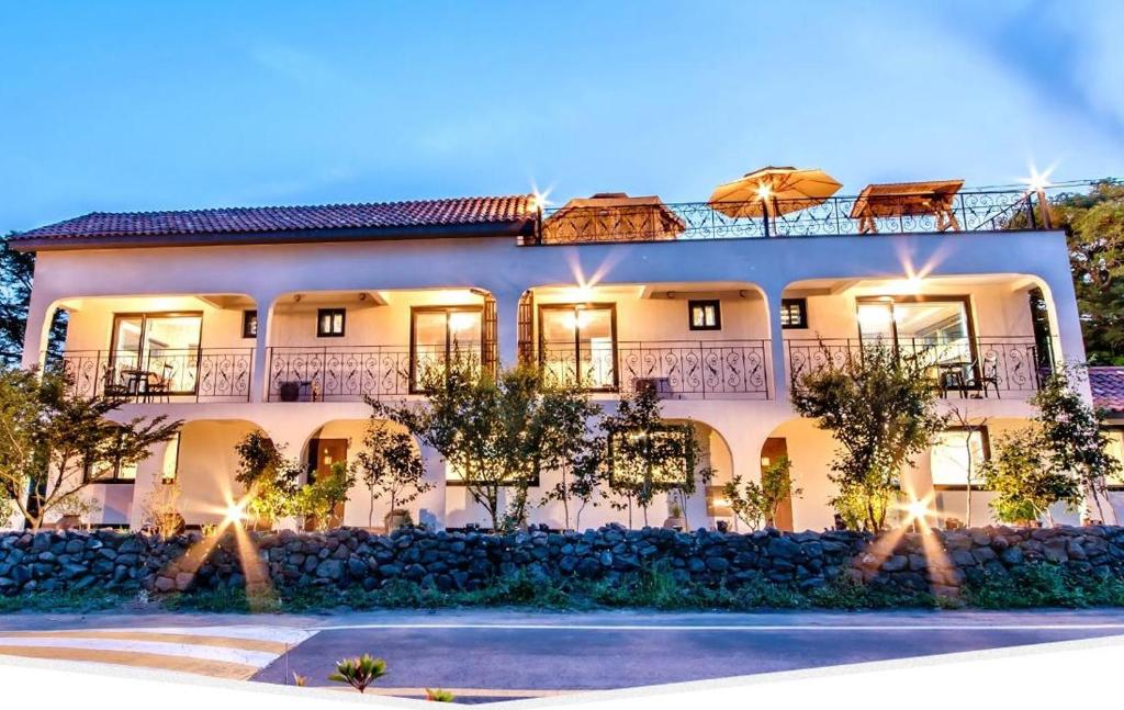 a large white building with lights on it at Dongbackdongsan Pension in Jeju