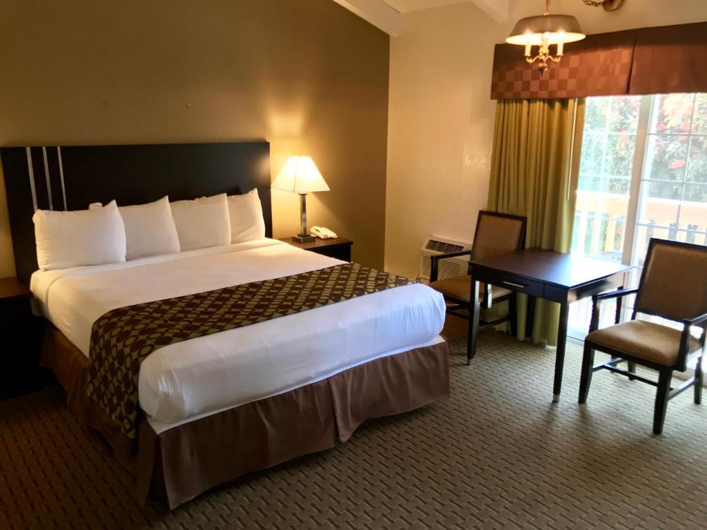 a hotel room with a large bed and a desk at Fireside Inn in Morro Bay