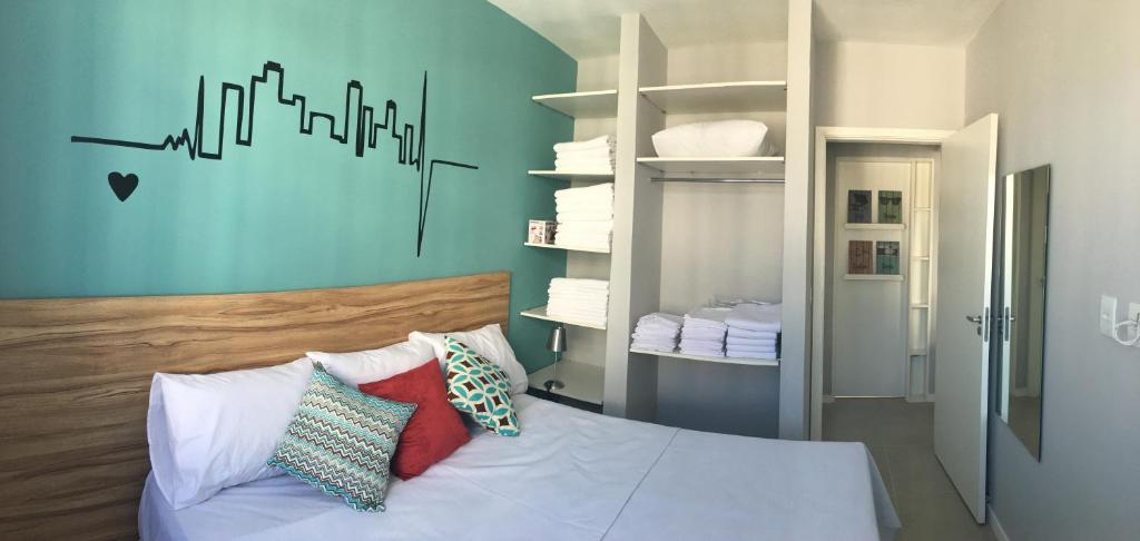 a bedroom with a bed with pillows on it at Loft Paris in Niterói