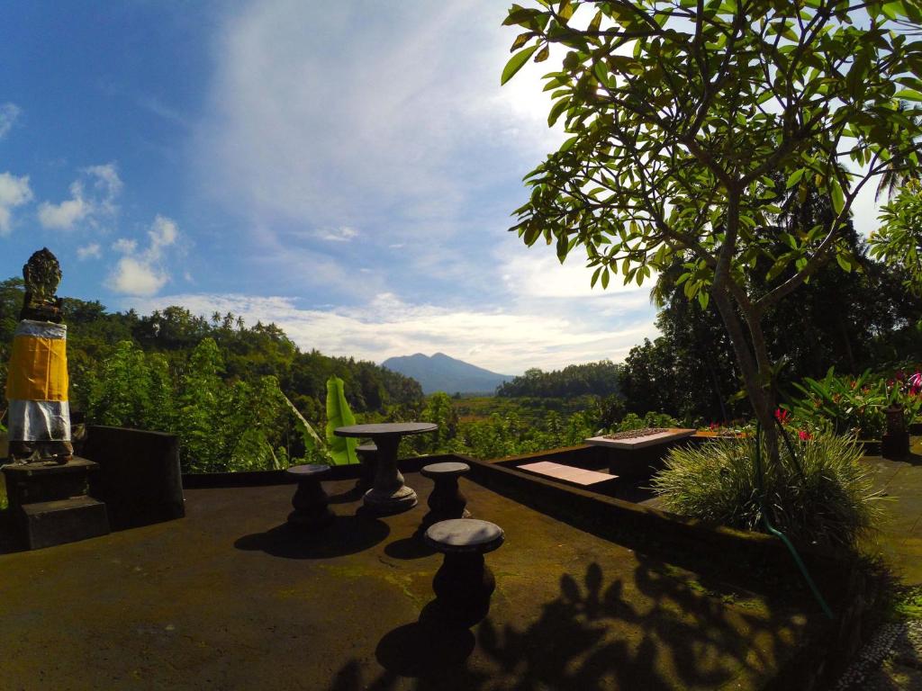 a patio with a table and a view of a mountain at Pondok Batur Indah Homestay Karangasem in Tirtagangga
