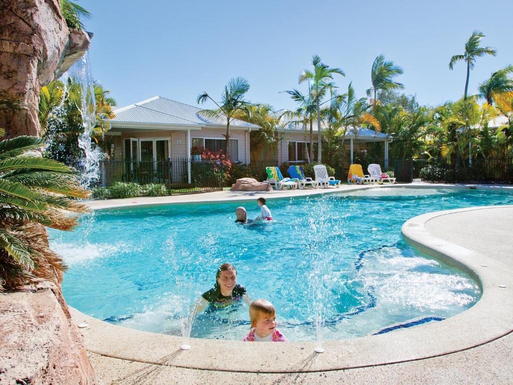 two children playing in a pool with a swimming pool at NRMA Treasure Island Holiday Resort in Gold Coast
