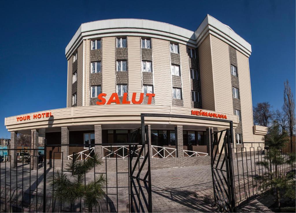 ein großes Gebäude mit einem Saul-Schild drauf in der Unterkunft Salut Hotel in Bischkek