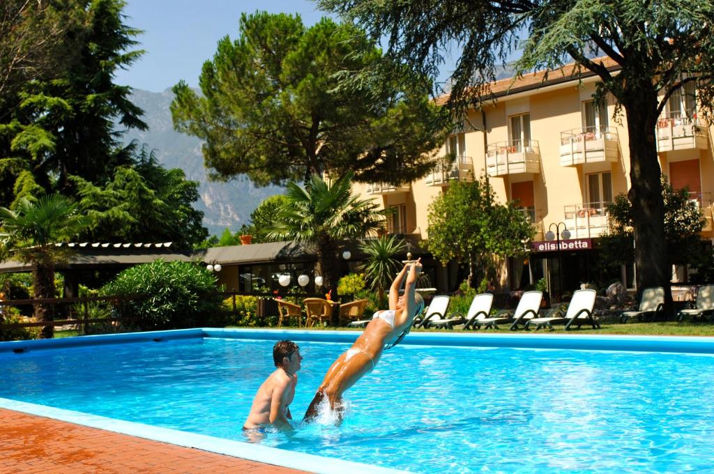 dos personas en una piscina en un hotel en Hotel Elisabetta, en Nago-Torbole