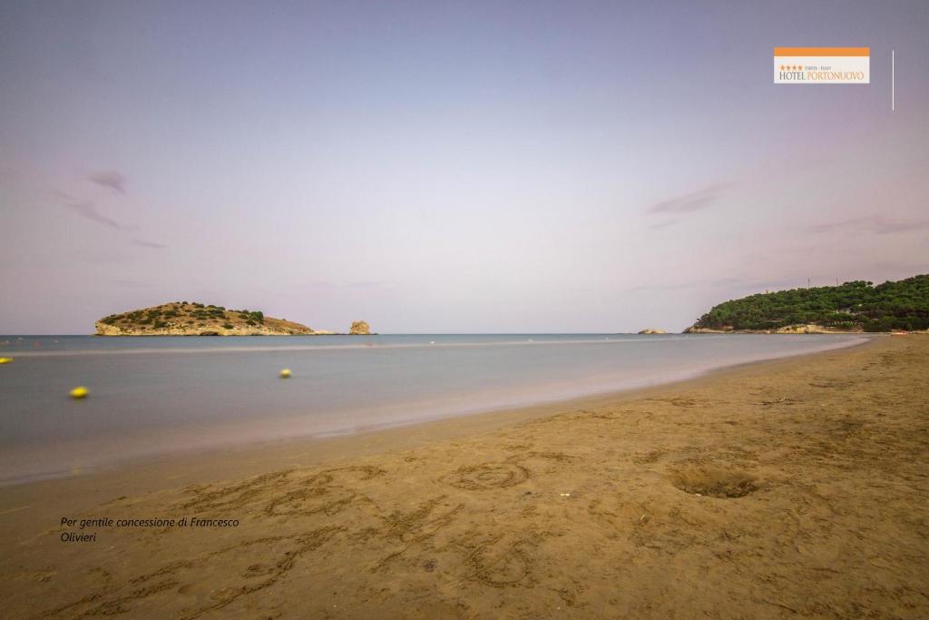 an empty beach with an island in the distance at Hotel Portonuovo in Vieste