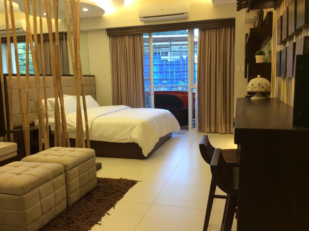 a hotel room with a bed and a living room at Pico de Loro Lagoon View in Nasugbu