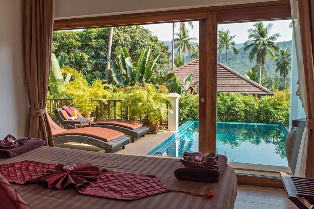a bedroom with a bed and a view of a pool at Tropical Season Villa Resort in Mae Nam
