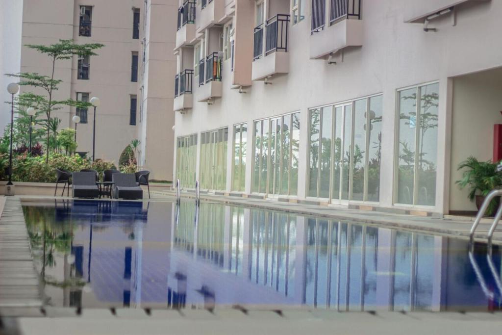 a building with a swimming pool in front of a building at Wjy Apartment Margonda Residence 5 in Depok