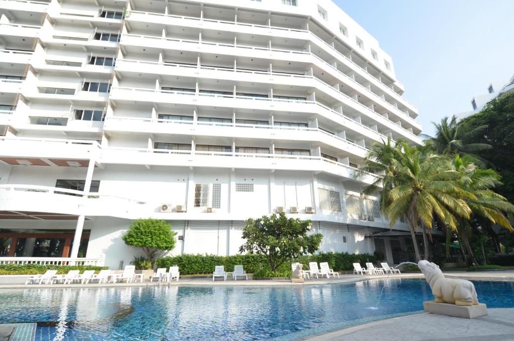 a large building with a swimming pool in front of a building at Welcome Plaza Hotel Pattaya in Pattaya Central