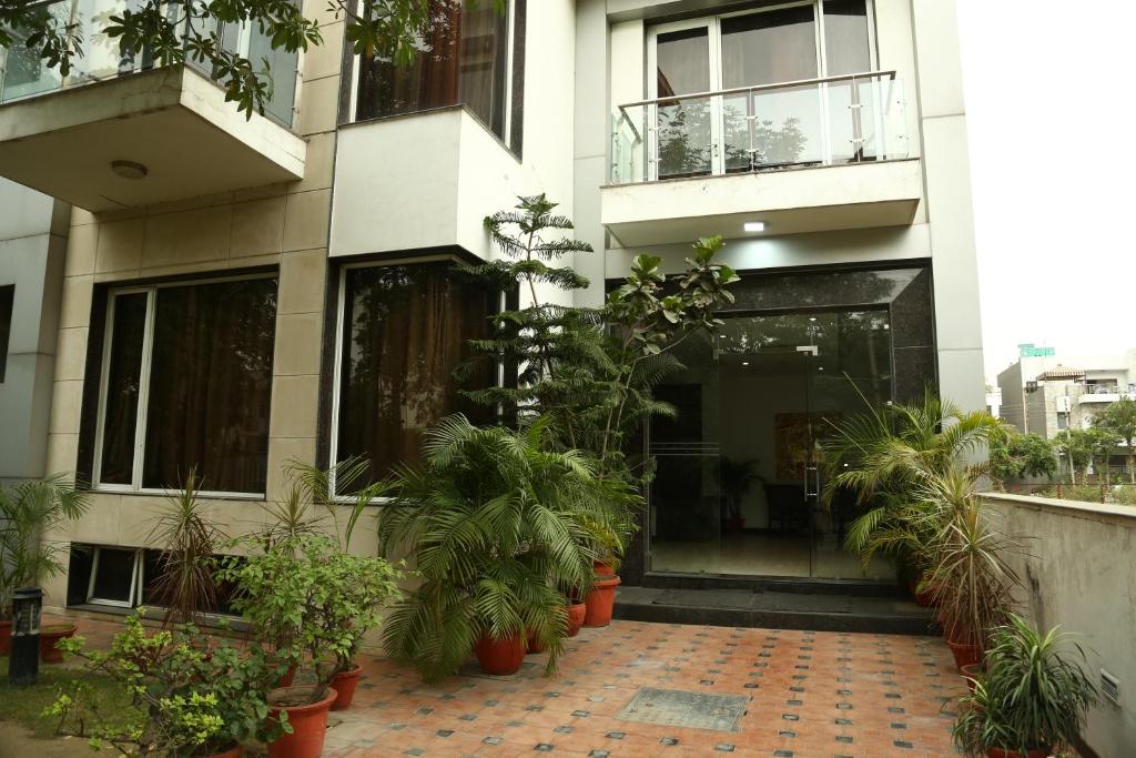ein Gebäude mit Topfpflanzen davor in der Unterkunft Imperial Apartments Huda City in Gurgaon