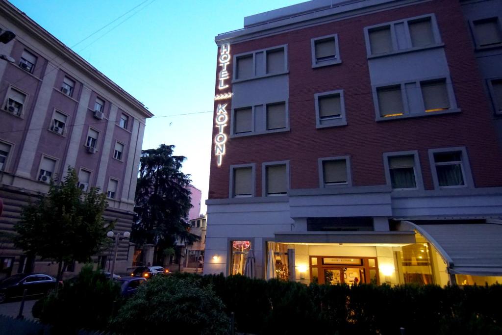a hotel with a sign on the side of a building at Boutique Hotel Kotoni in Tirana