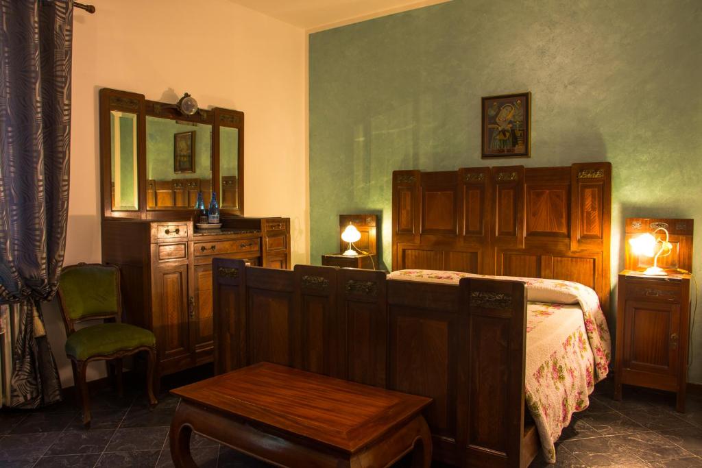 een slaapkamer met een bed, een tafel en een spiegel bij Al Parco in Curtatone