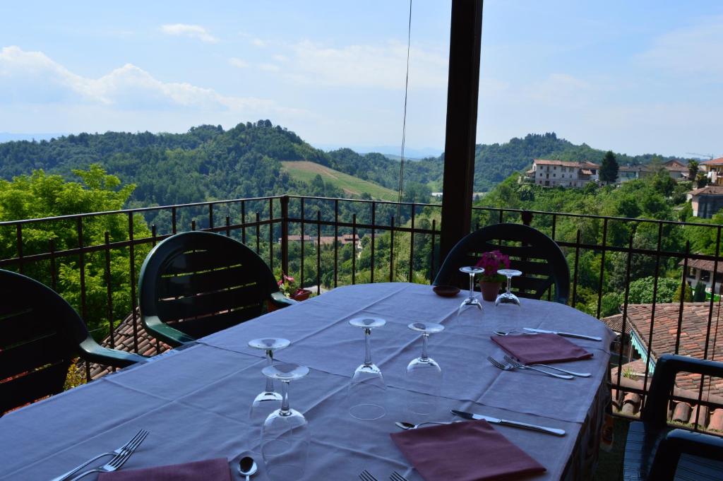 uma mesa com copos de vinho em cima de uma varanda em Di Vin Roero em Vezza d'Alba