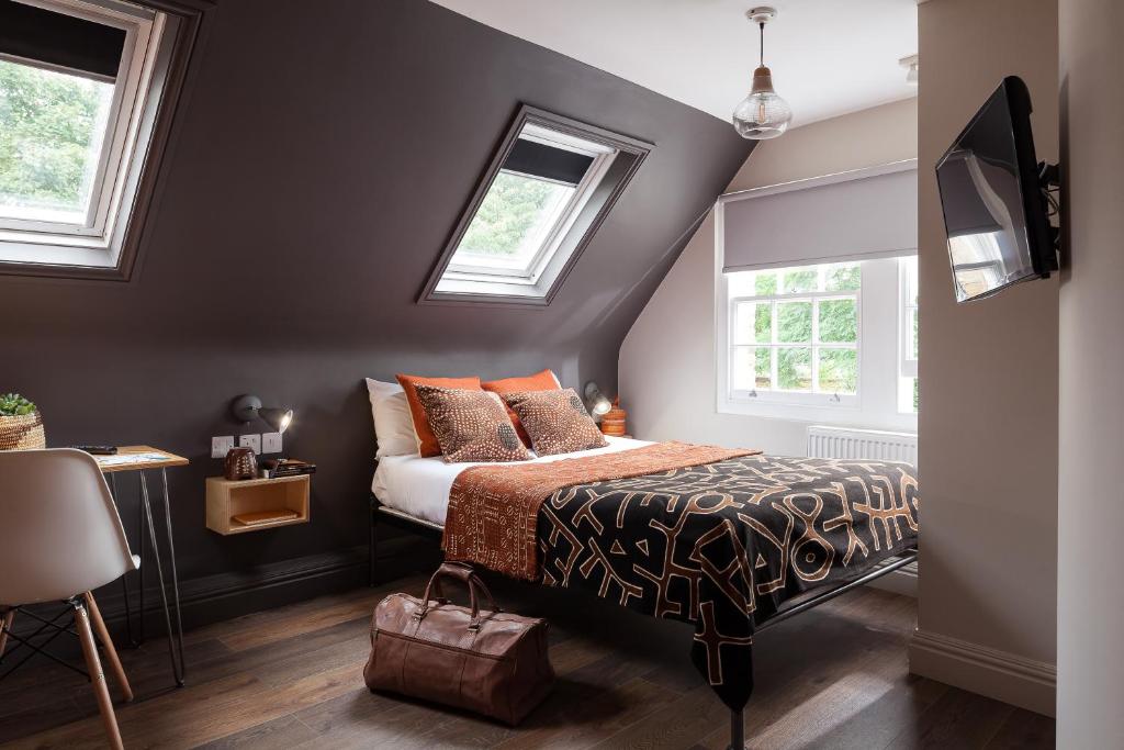 فندق بيكهام رومز في لندن: غرفة نوم بسرير ونوافذ