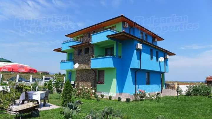 una casa colorida con una mesa delante en Complex Koral en Sinemorets