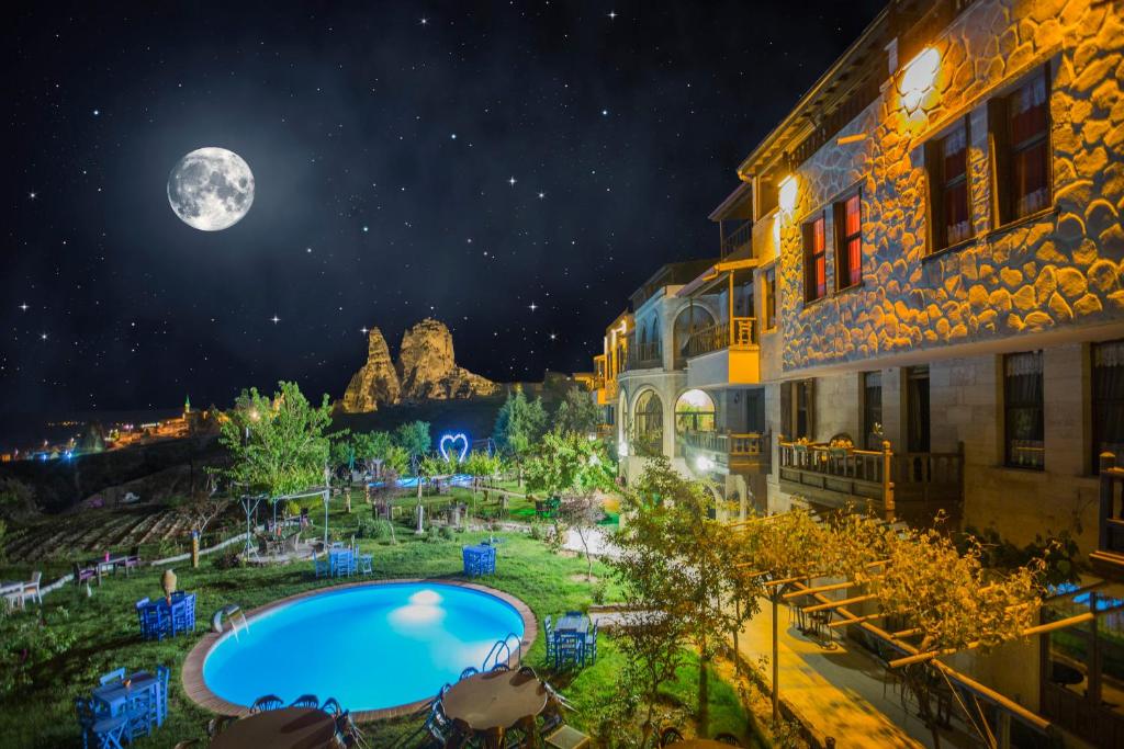 a view of a pool at night with the moon at Karlık Evi Hotel - Special Category in Uçhisar