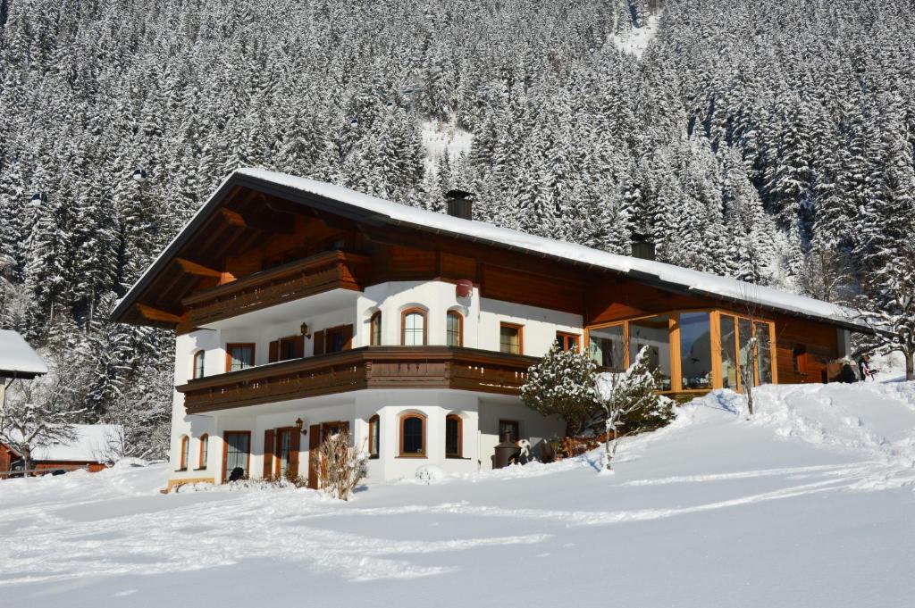 een huis in de sneeuw met sneeuw bedekte bomen bij Ferienwohnung Fiel in Sankt Gallenkirch
