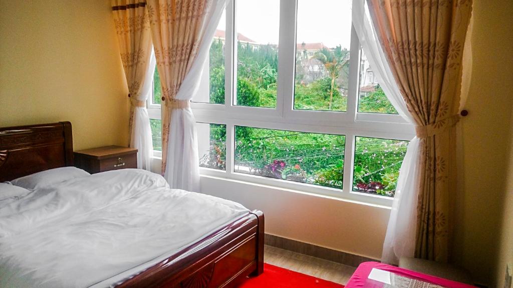 sypialnia z łóżkiem i dużym oknem w obiekcie ATP Guesthouse w mieście Da Lat