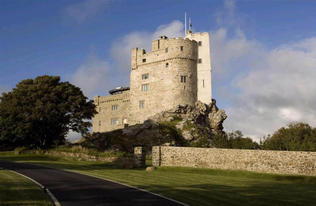 un castillo en la cima de una colina con una carretera en Roch Castle en Roch