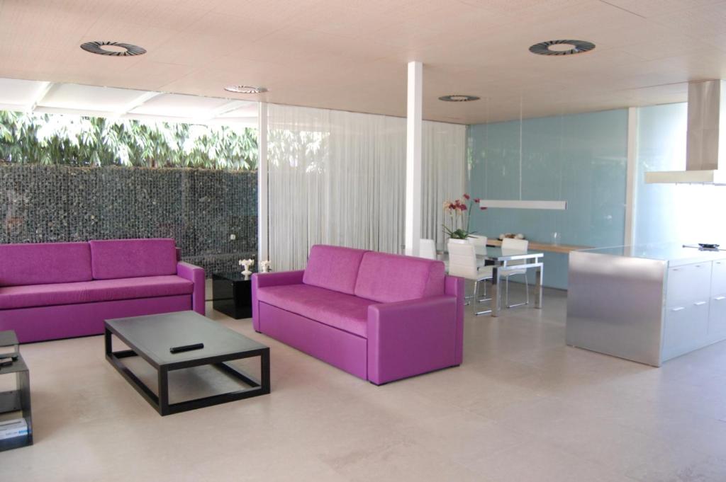 マスパロマスにあるeó Maspalomas Villaの紫色の家具とテーブル付きのリビングルーム