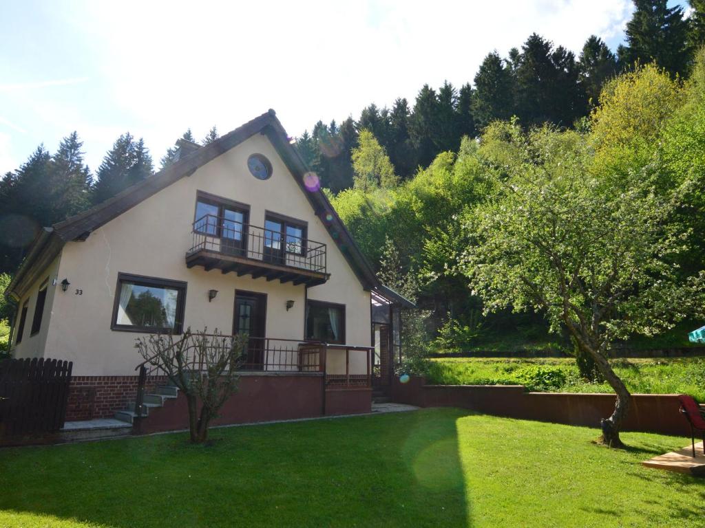 a white house with a balcony and a yard at Holiday home with garden in Hellenthal Eifel in Hellenthal